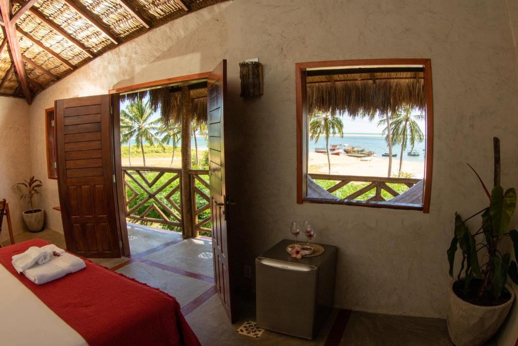 a bedroom with a bed and a view of the ocean at Pousada Bate Vento in Itarema