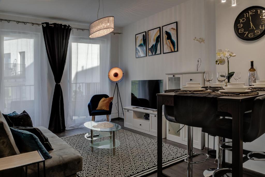 a living room with a table and a couch at Modern Apt near Old Town - King Bed - Free Parking in Poznań