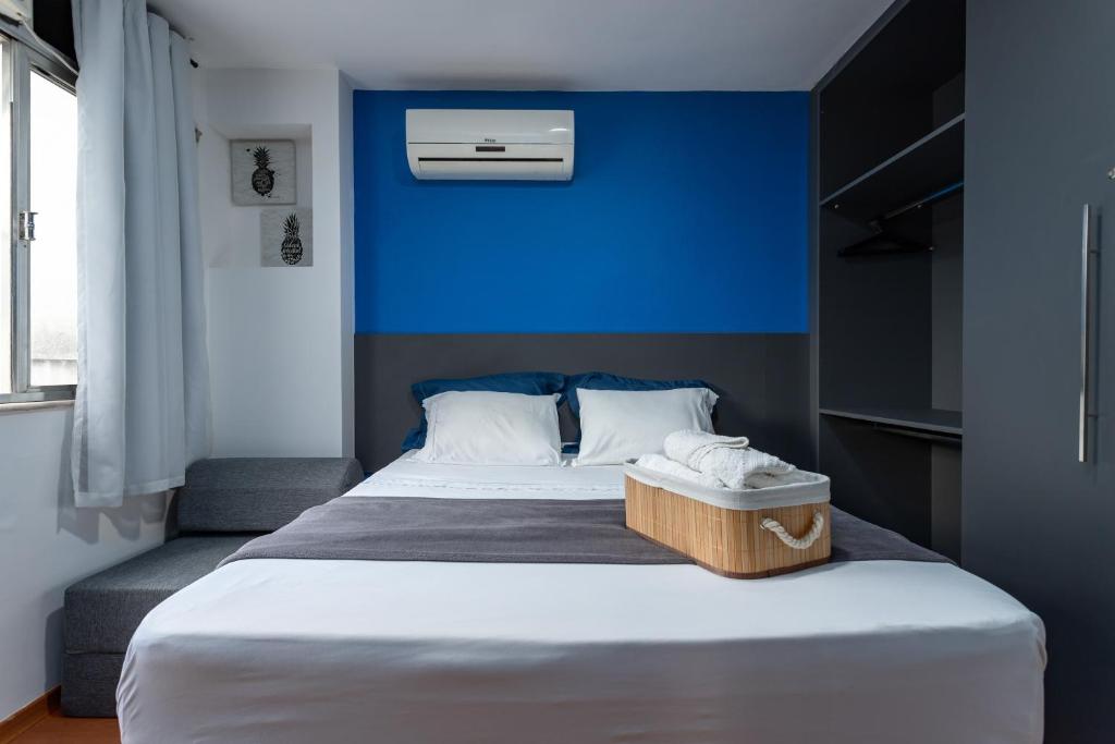 a bedroom with a large bed with a blue wall at Apartamento especial- Icarai Niterói in Niterói