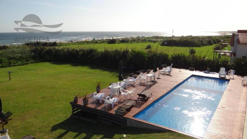 a swimming pool in a yard with chairs at Audencia del Mar in La Paloma