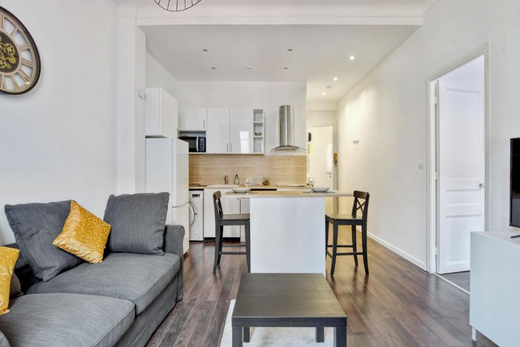 un salon avec un canapé et une cuisine dans l'établissement Appartement Oscarmony - Welkeys, à Nice