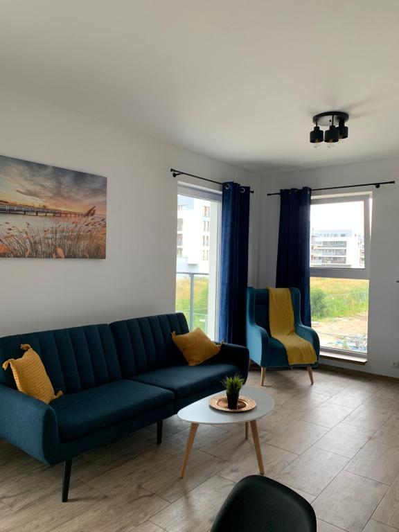 a living room with a blue couch and two chairs at Porto Bianco III in Rumia