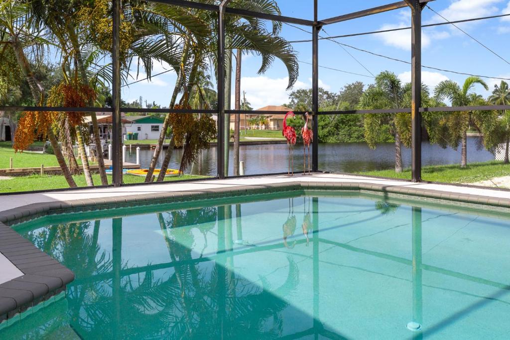 a swimming pool in front of a house with two women at Punta Paradise- Enjoy a 4 bedroom pool home in Punta Gorda