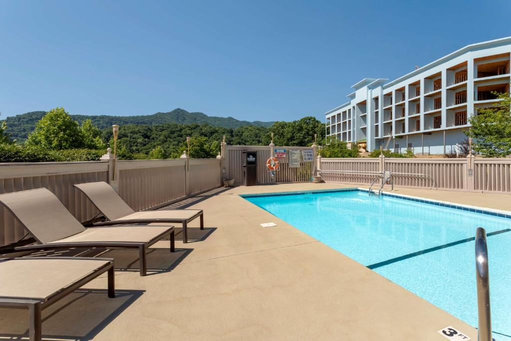 a swimming pool with lounge chairs and a building at Best Western Smoky Mountain Inn in Waynesville