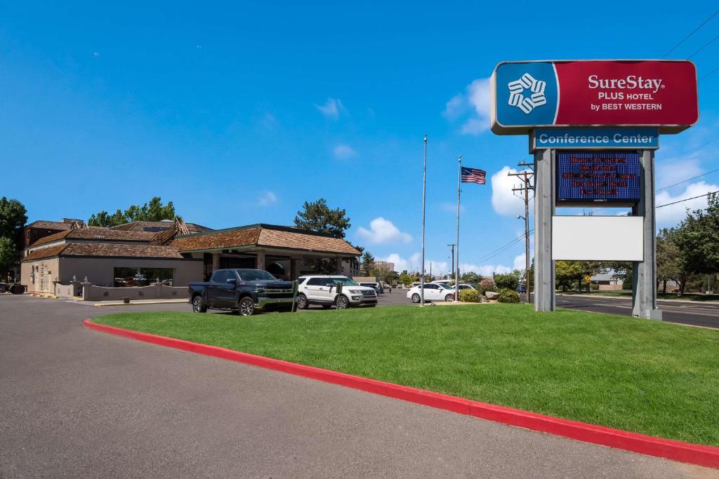 SureStay Plus Hotel by Best Western Reno Airport في رينو: محطة وقود مشمسة مع سيارات متوقفة في موقف للسيارات