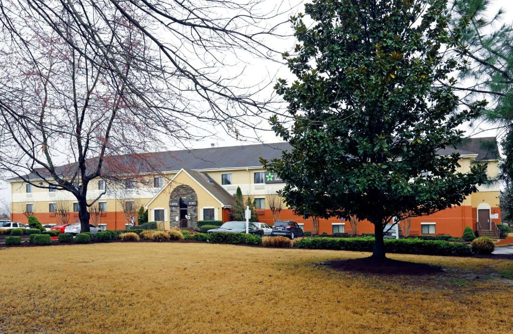 a large building with a tree in front of it at Sonesta Simply Suites Memphis in Memphis