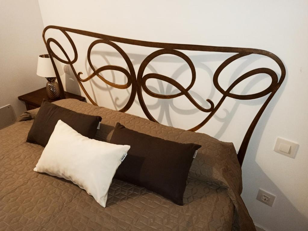 a bed with a black iron headboard and pillows at Casa Rural Casona Camino Pedraza - 4 Estrellas in Arcones