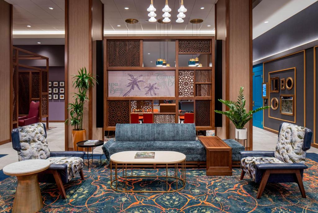 坦帕的住宿－Hyatt House Tampa Downtown，大堂设有蓝色的沙发和两把椅子