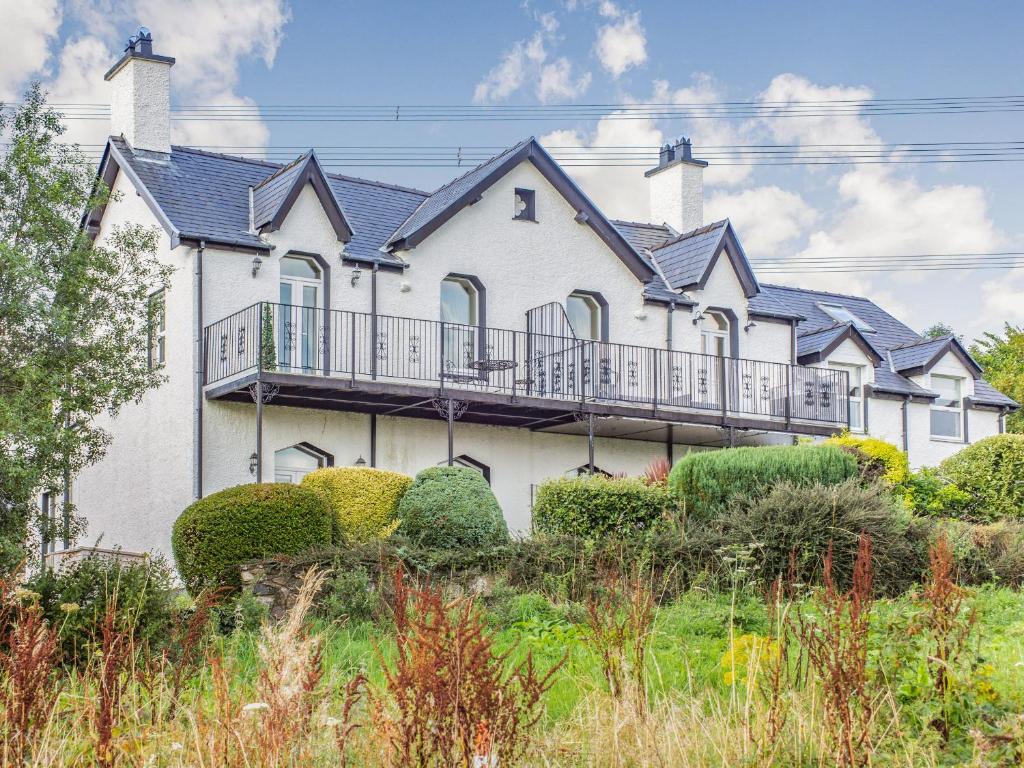 a large white house with balconies and bushes at Menai View in Llanfairpwllgwyngyll