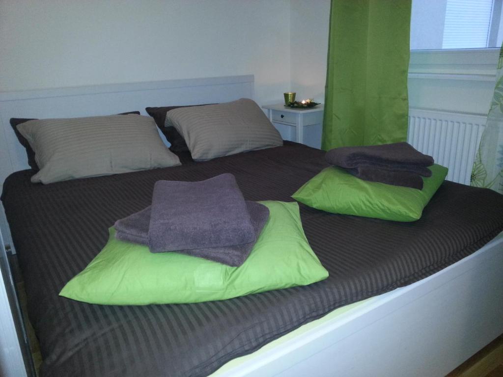 Una cama con almohadas verdes y moradas. en Apartment Capital Town-free parking, en Zagreb
