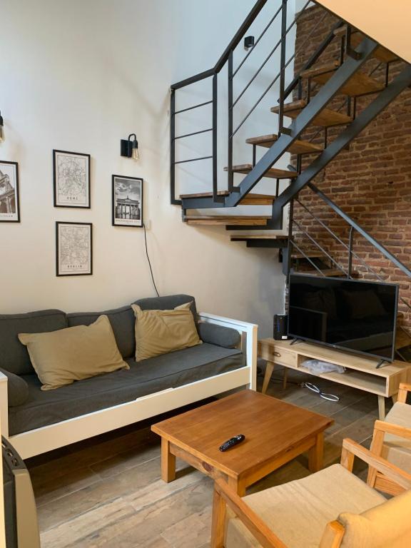 a living room with a couch and a staircase at 11 de abril. Loft in Bahía Blanca