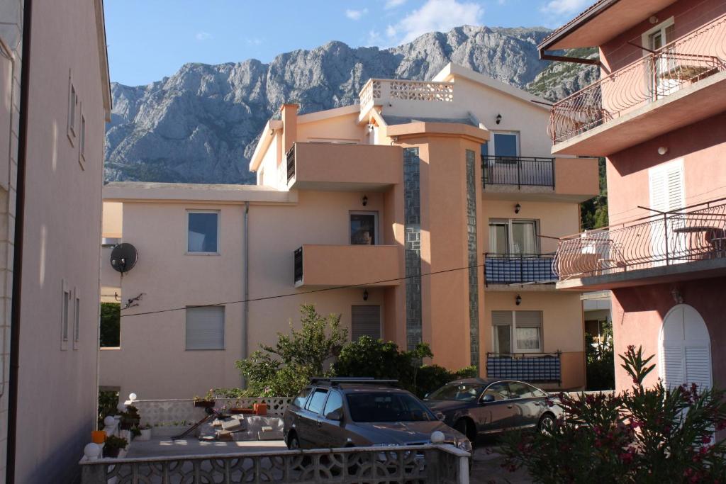a view of a building with mountains in the background at Apartments and rooms with parking space Makarska - 6834 in Makarska