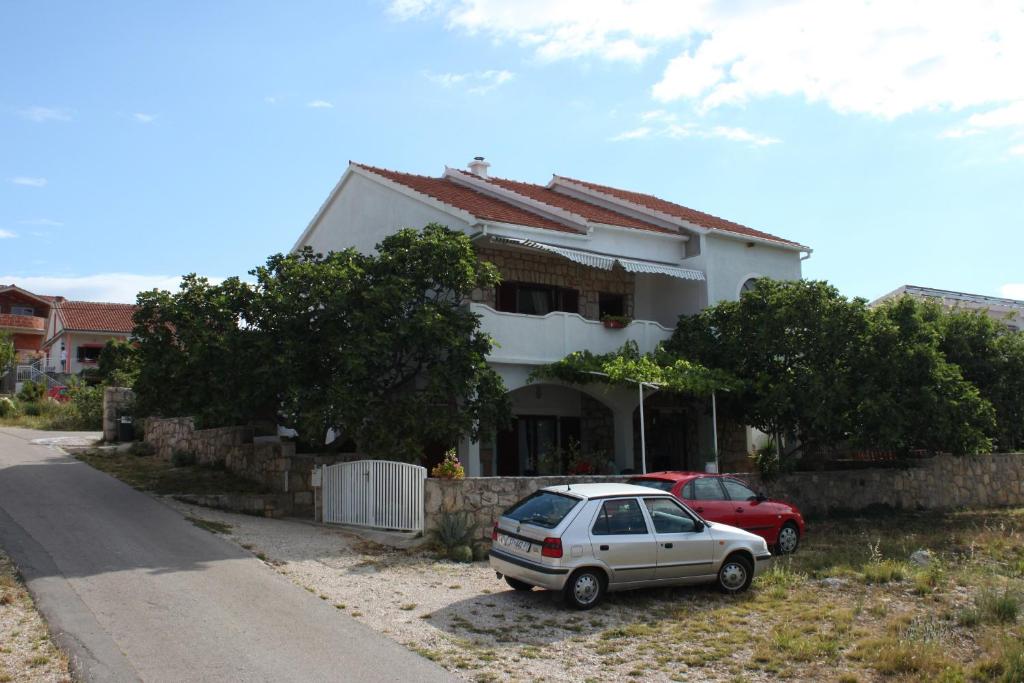 um carro branco estacionado em frente a uma casa em Apartments with a parking space Maslenica, Novigrad - 6548 em Jasenice