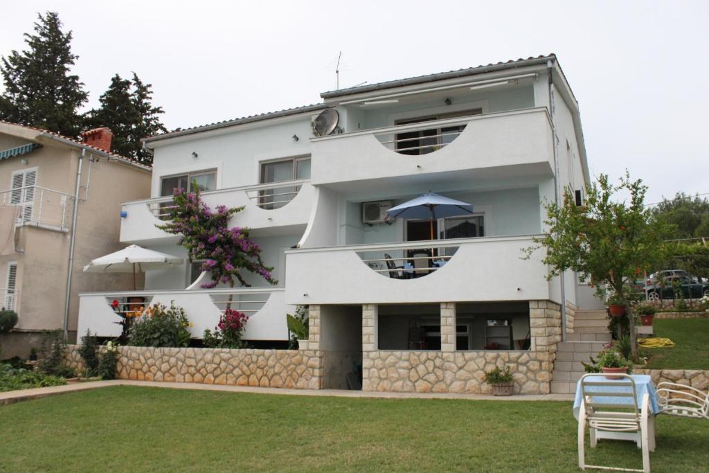 a white building with a yard in front of it at Apartments by the sea Posedarje, Novigrad - 6617 in Posedarje