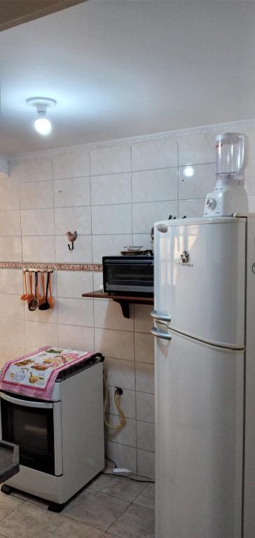 cocina con nevera blanca y fogones en Condomínio Alto da Boa Vista, en Campos do Jordão
