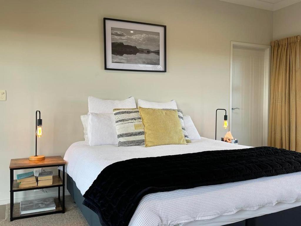 a bedroom with a large white bed with pillows at Views to unwind - self contained unit w/king bed in Ruakaka
