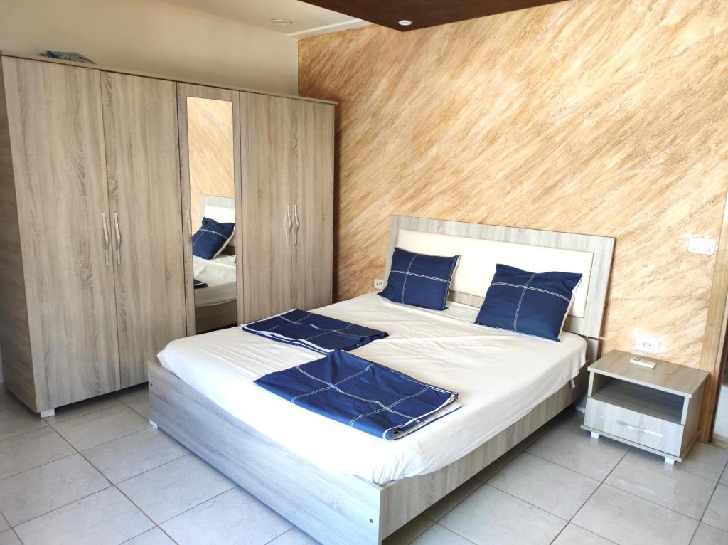 1 dormitorio con 1 cama grande con almohadas azules en Appart S plus 2 à Sousse zone touristique en Sousse