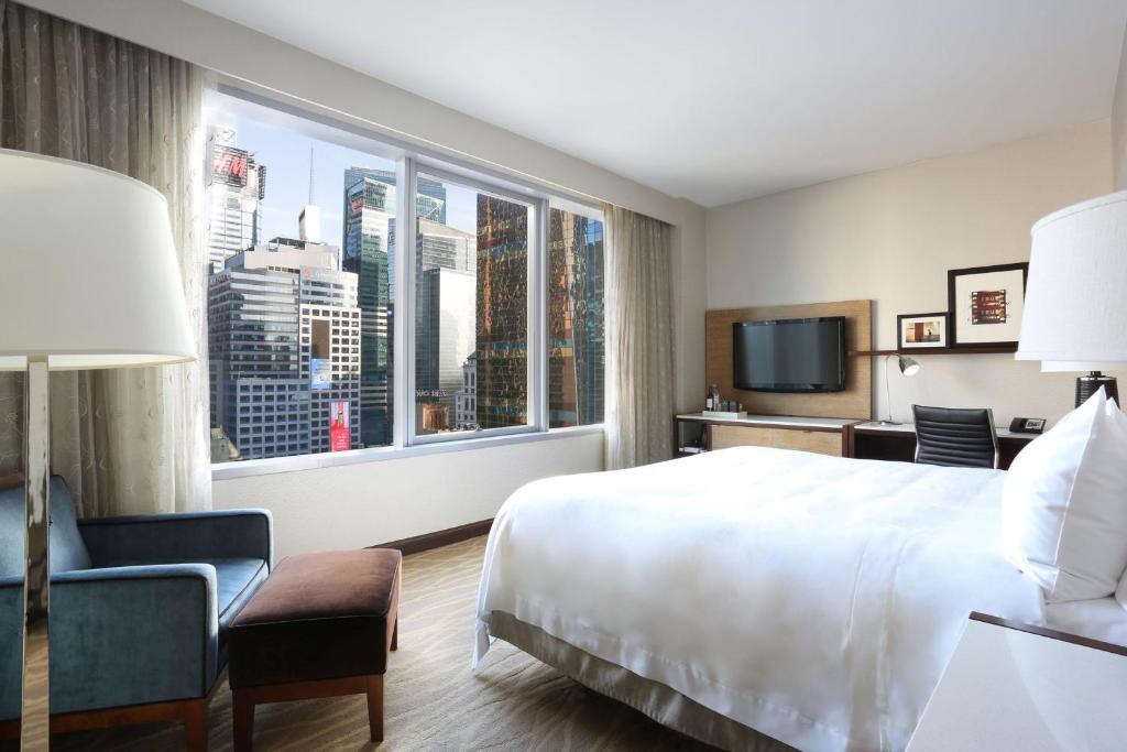 a hotel room with a large bed and a large window at InterContinental New York Times Square by IHG in New York