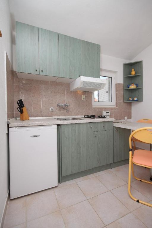 kuchnia z zielonymi szafkami i białą lodówką w obiekcie Apartments with a parking space Povljana, Pag - 6501 w mieście Povljana