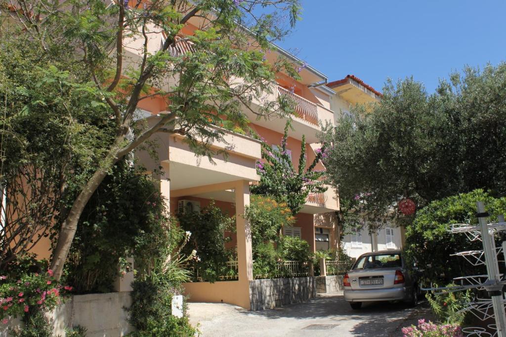 un edificio con un coche aparcado delante de él en Apartments by the sea Tucepi, Makarska - 6806 en Tučepi