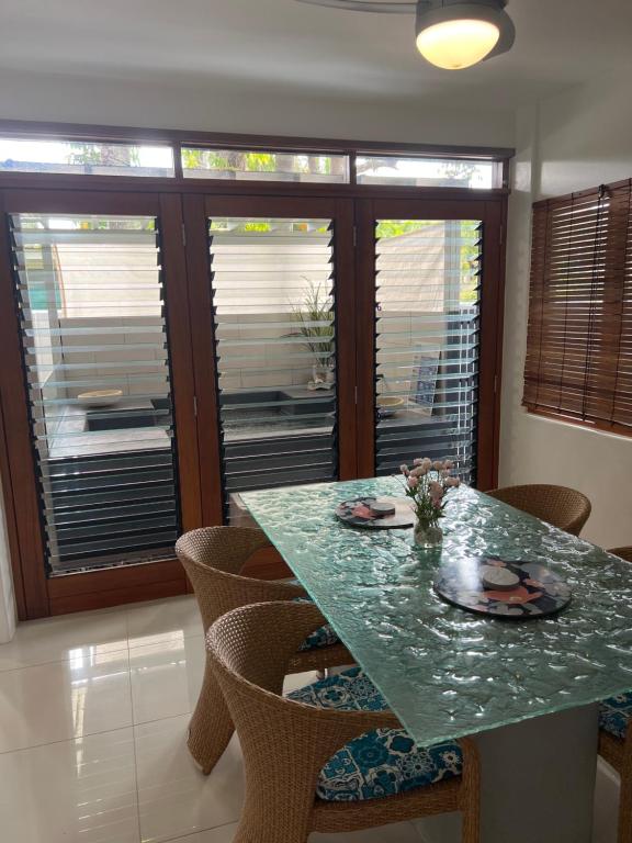 een eetkamer met een groene tafel en stoelen bij Beachside Apartment 1 with plunge pool in Port Douglas