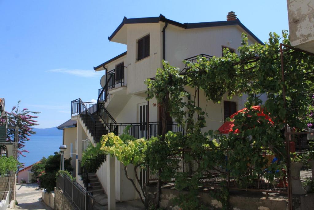 a white building with stairs and plants at Studio Podaca 6902c in Podaca