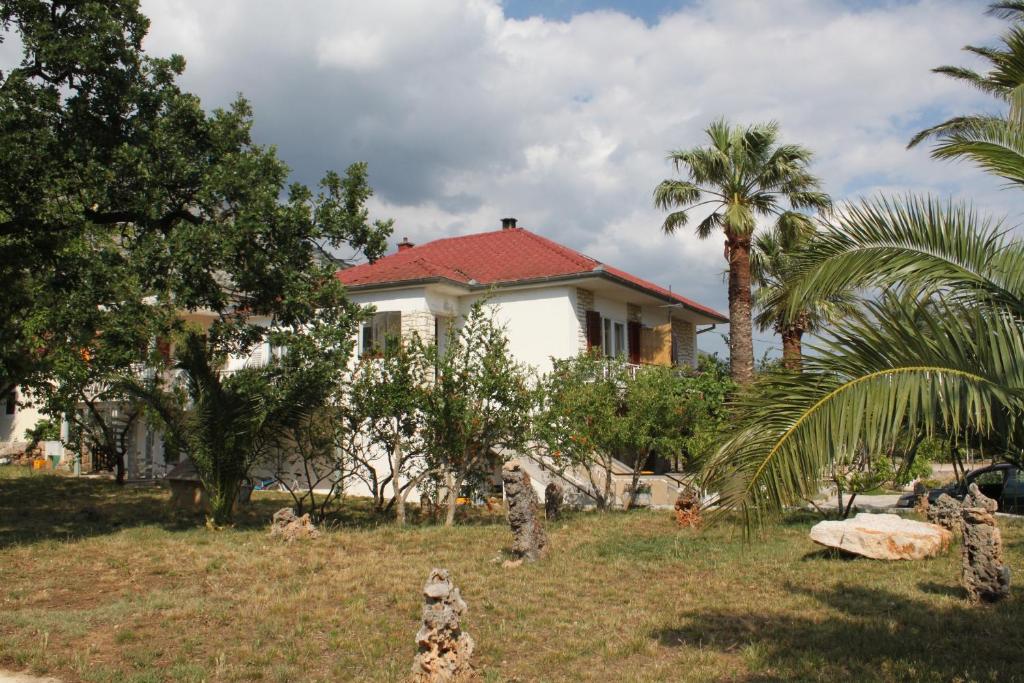 a white house with palm trees in front of it at Apartments by the sea Starigrad, Paklenica - 6586 in Starigrad