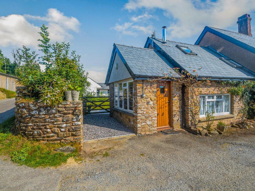 WithypoolにあるCreenagh's Cottageの茶色の扉と石壁の石造りの家