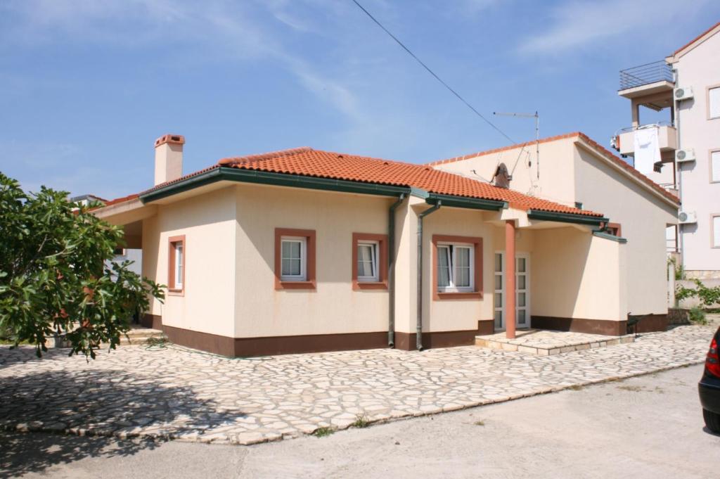 a small house with a driveway in front of it at Holiday house with a parking space Novalja, Pag - 6492 in Novalja