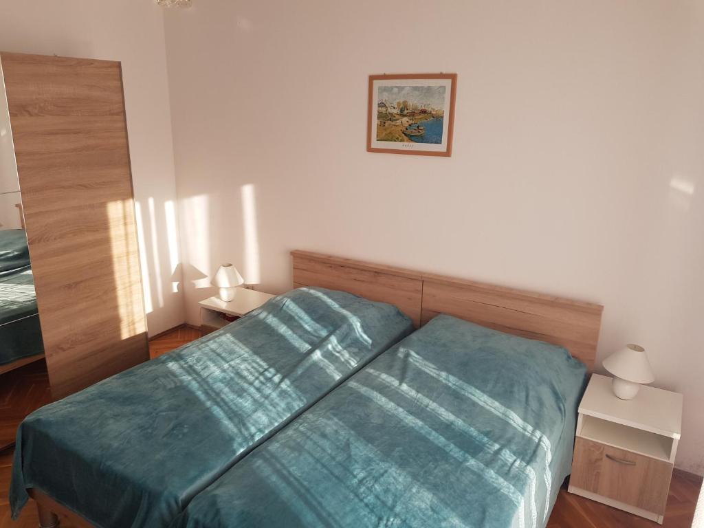 sypialnia z łóżkiem z zieloną kołdrą w obiekcie Apartment Novalja 6491b w Novalji