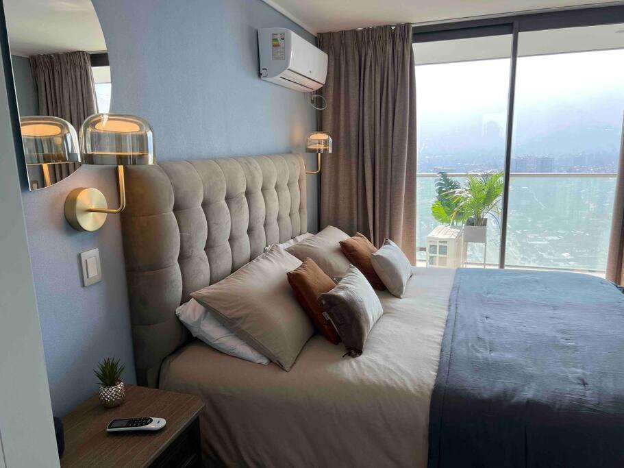 een slaapkamer met een groot bed en een groot raam bij Super Luxury apartment 37th floor en zona de lujo in Santiago
