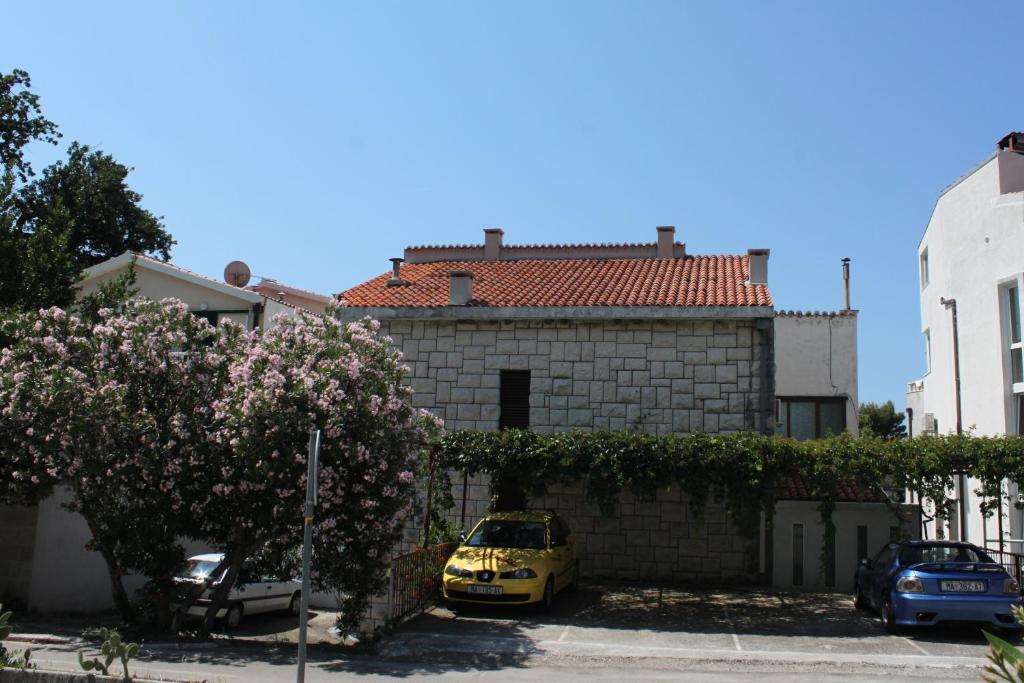 a yellow car parked in front of a brick building at Apartments by the sea Brela, Makarska - 6686 in Brela