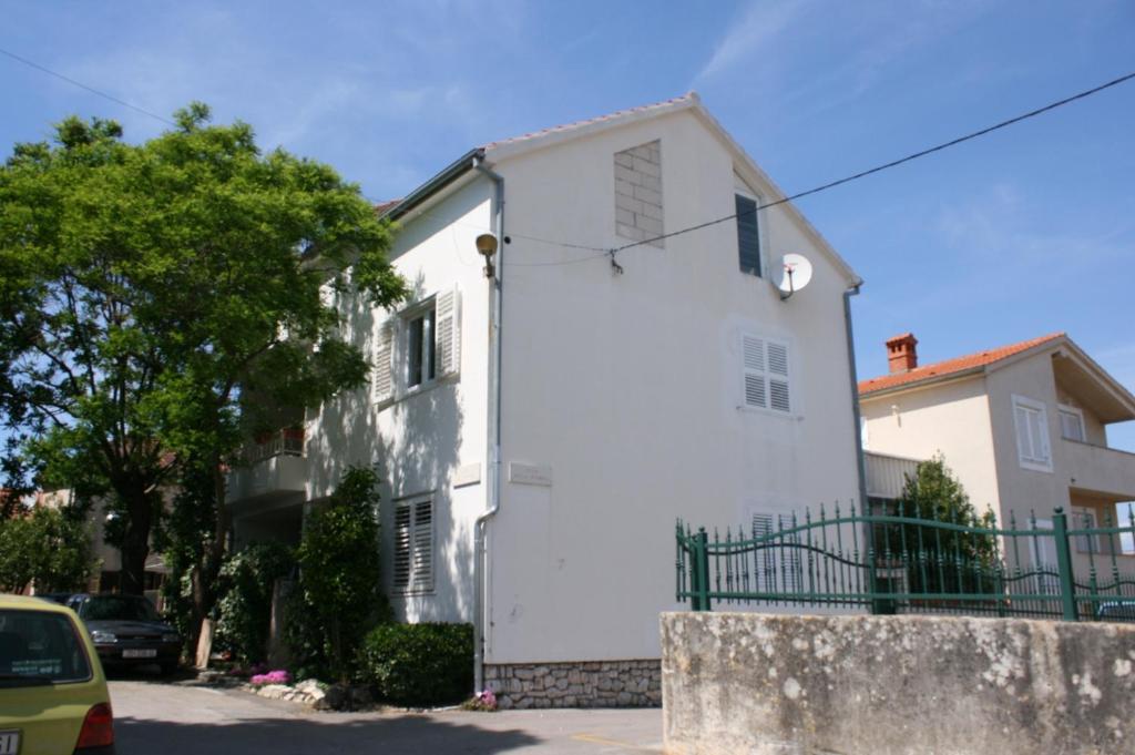 a white house with a car parked in front of it at Apartments with a parking space Biograd na Moru, Biograd - 6446 in Biograd na Moru