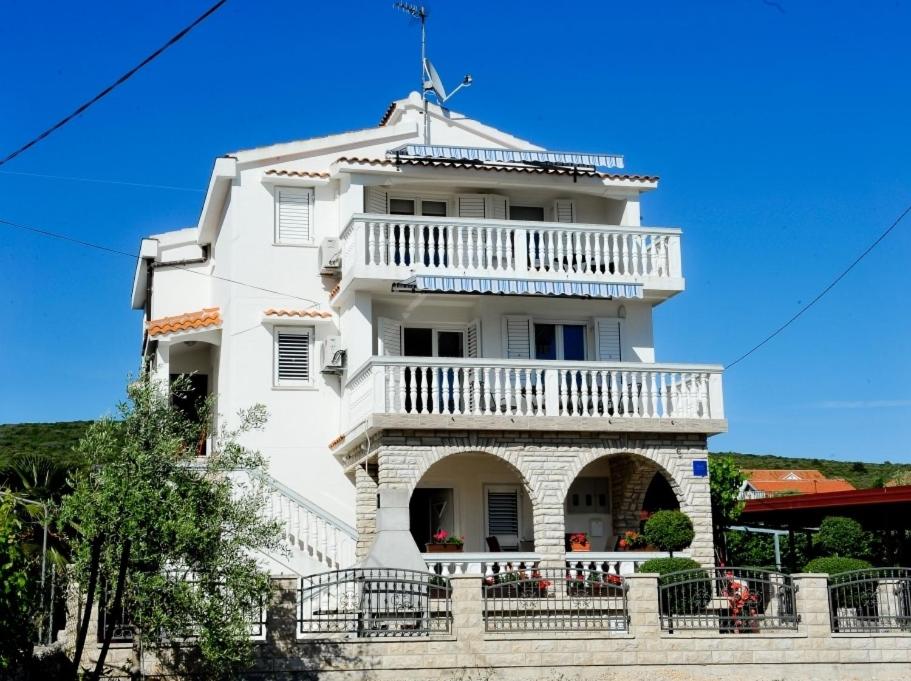- un bâtiment blanc avec un balcon au-dessus dans l'établissement Apartments with a parking space Sukosan, Zadar - 6131, à Sukošan