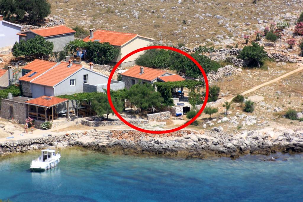 an aerial view of a house with a boat in the water at Secluded fisherman's cottage Cove Statival, Kornati - 8164 in Pristanišće