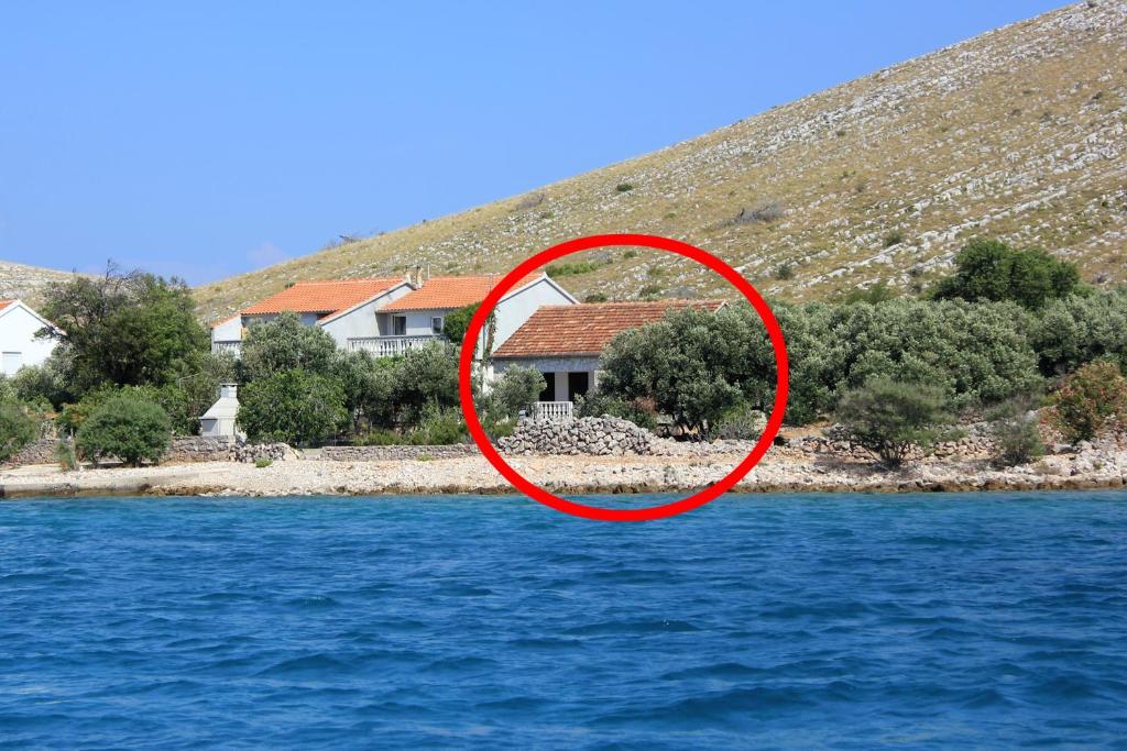 a house in the middle of a body of water at Secluded fisherman's cottage Cove Suha Punta, Kornati - 8168 in Pinizelić