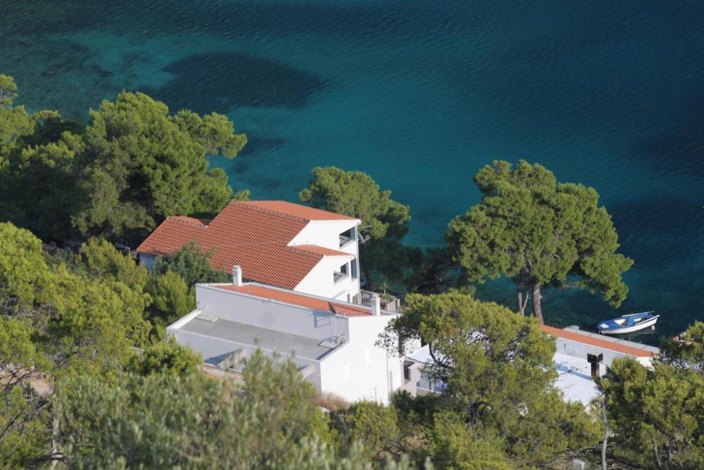 a house on top of a hill next to the water at Apartments by the sea Pasadur, Lastovo - 8337 in Ubli