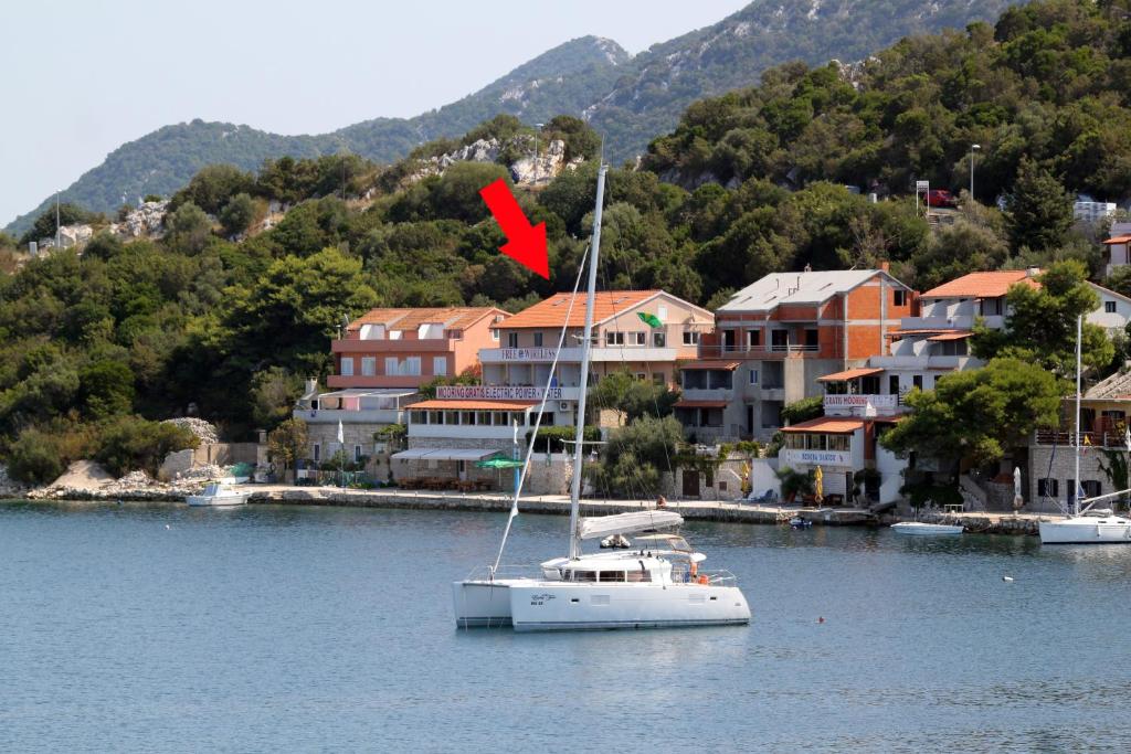 a sailboat in the water in front of a city at Apartment Zaklopatica 8342b in Lastovo