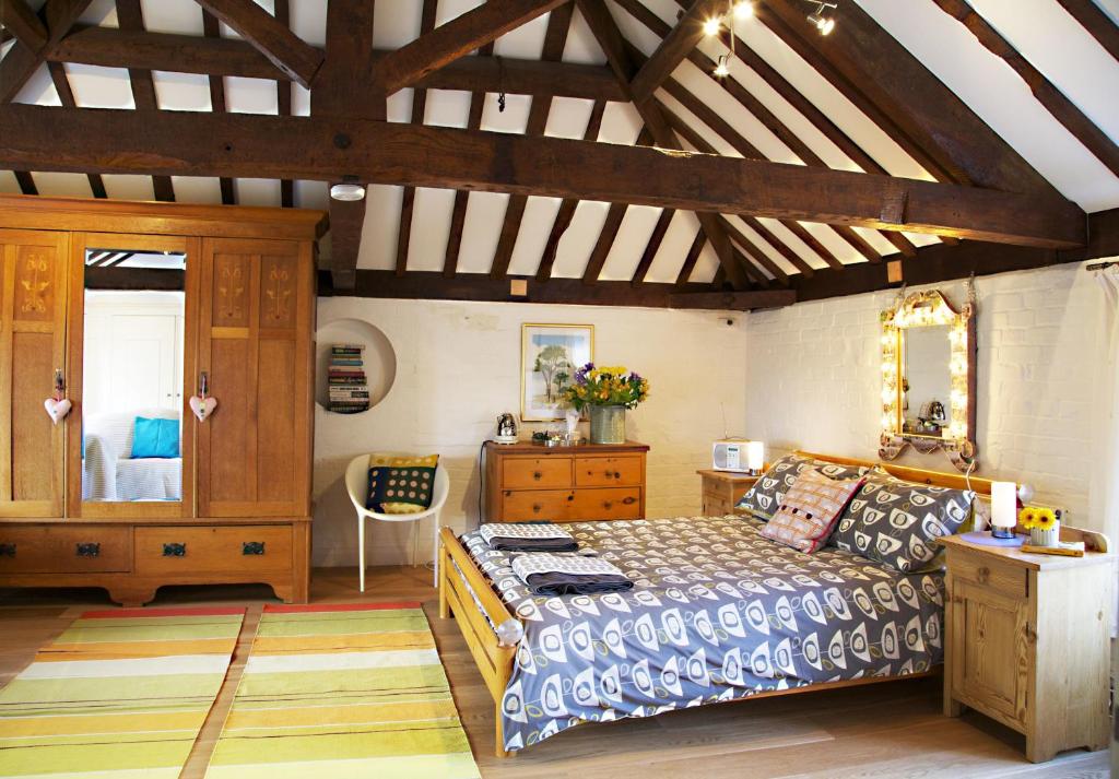 a large bedroom with a bed and a dresser at B&B at The Old Mill in Devizes