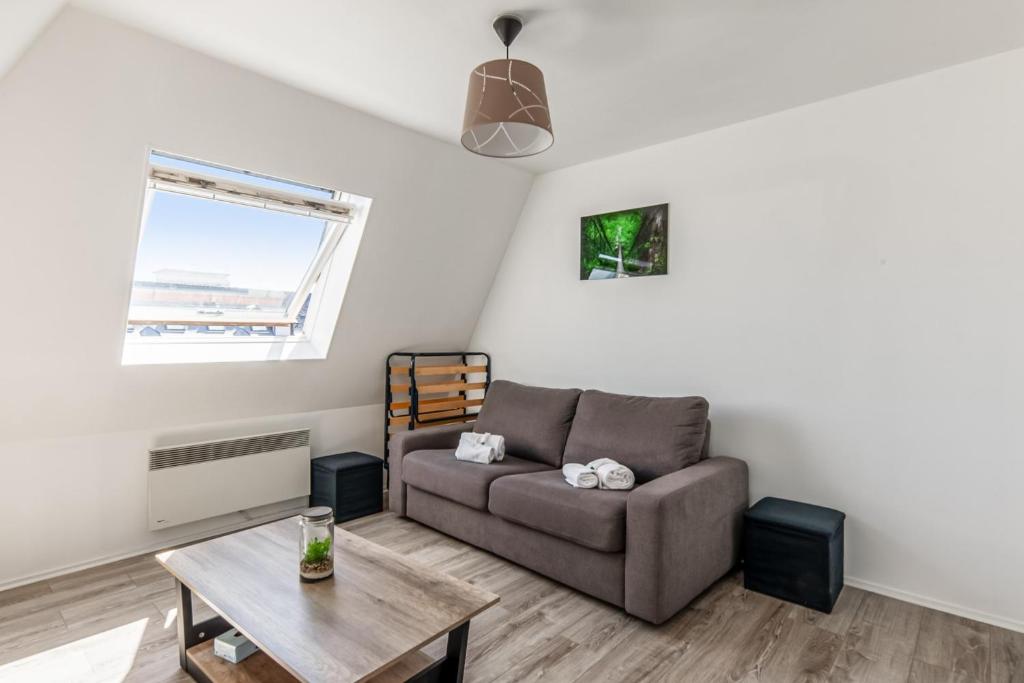 un salon avec un canapé et une table dans l'établissement Appartement Risco - Welkeys, à Villers-sur-Mer