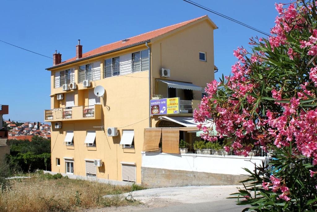 een gebouw met roze bloemen ervoor bij Rooms with a swimming pool Preko, Ugljan - 8180 in Preko