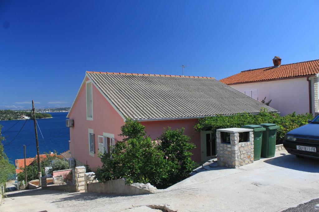 a pink house with a car parked in front of it at Seaside holiday house Kali, Ugljan - 8429 in Kali