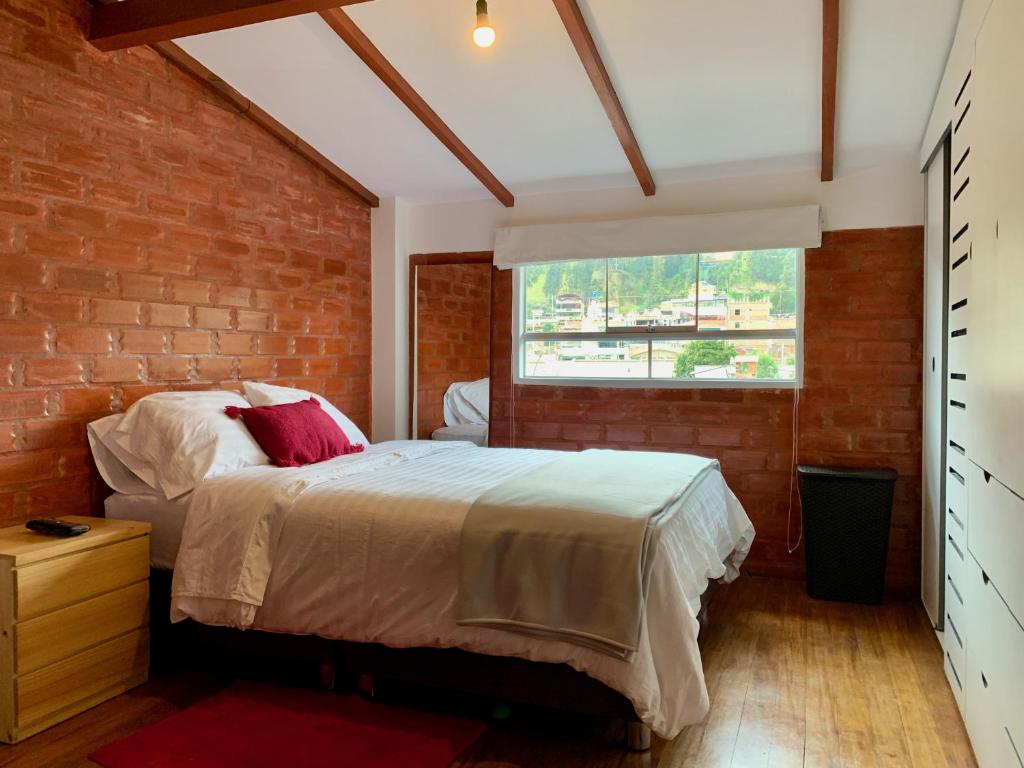 um quarto com uma cama e uma parede de tijolos em Departamentos Huaraz & Caraz em Huaraz