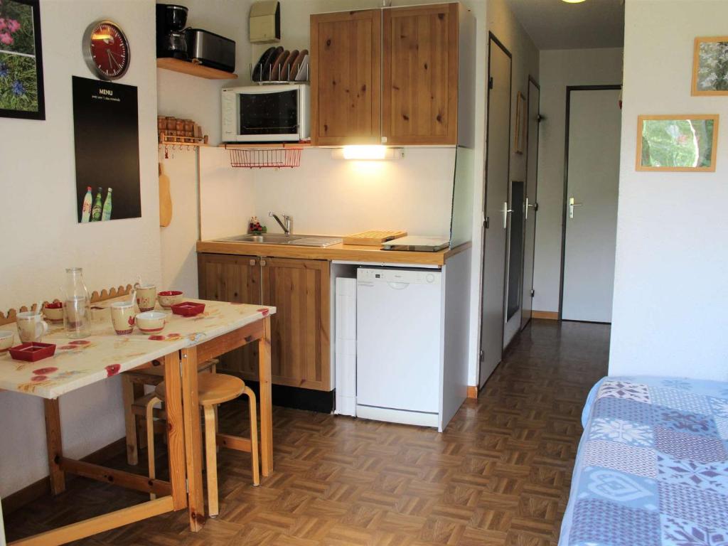 une cuisine avec une table et une petite cuisine avec un lit dans l'établissement Charmant T2 à Vars Sainte Marie, balcon sud, à 300m des pistes, navettes gratuites, animaux acceptés - FR-1-330B-196, à Vars