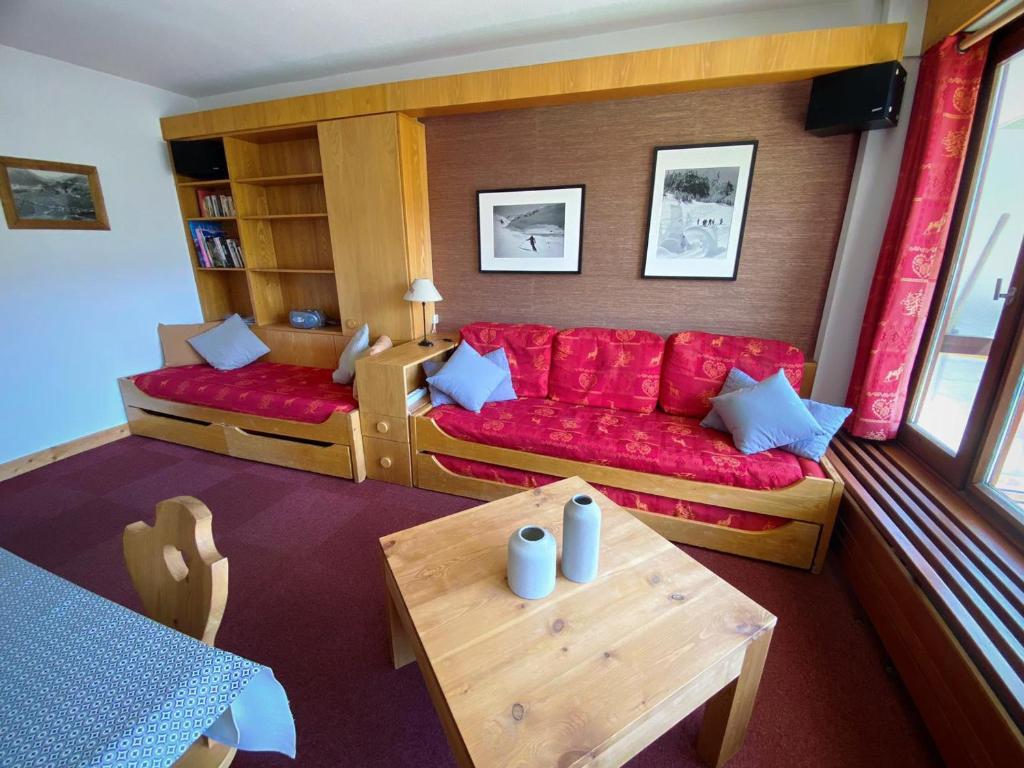 un salon avec un canapé rouge et une table dans l'établissement Appartement lumineux avec balcon, accès direct aux pistes - FR-1-502-370, à Tignes