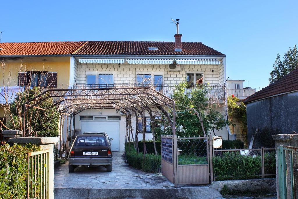 a car parked in front of a house with a garage at Apartments by the sea Kastel Stafilic, Kastela - 8621 in Kaštela