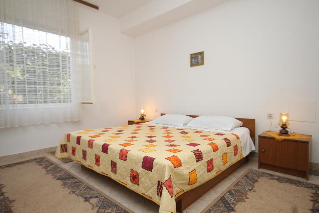 KukljicaにあるApartment Kukljica 8277bのベッドルーム1室(ベッド1台、ナイトスタンド2台、窓付)
