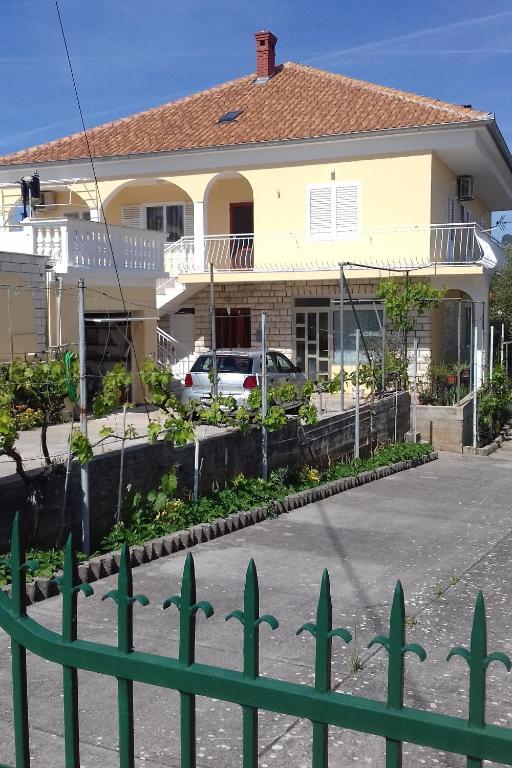 a house with a green fence in front of it at Apartment Kukljica 8277c in Kukljica