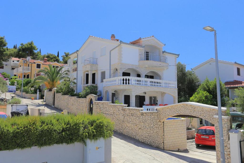 uma grande casa branca com uma parede de pedra em Apartments by the sea Okrug Gornji, Ciovo - 8625 em Trogir