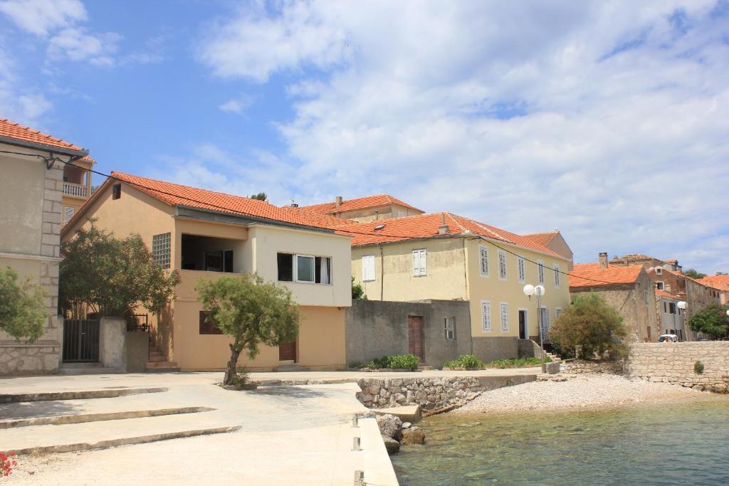 un grupo de casas junto a un cuerpo de agua en Apartments by the sea Sali, Dugi otok - 8194, en Sali